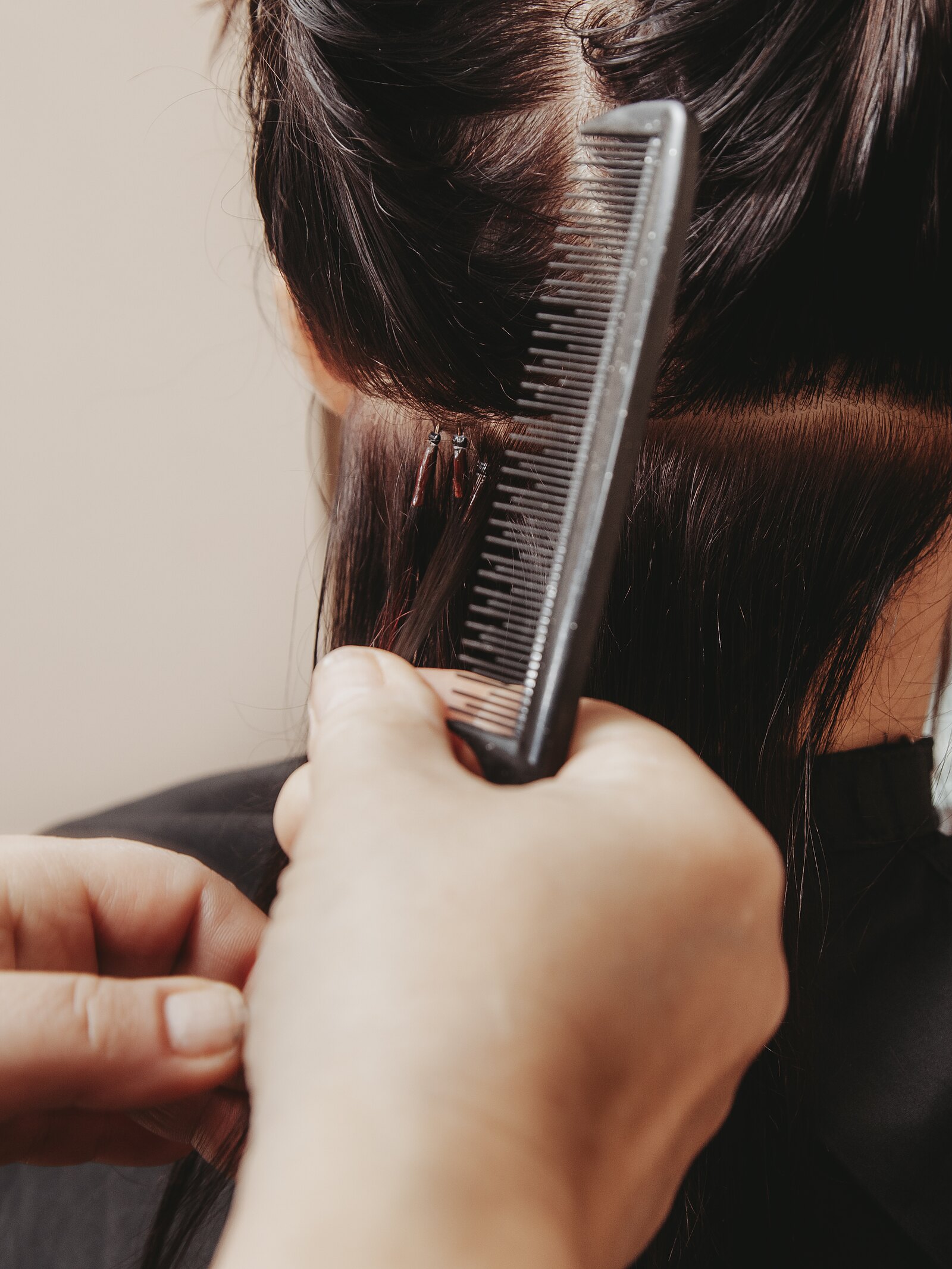Een lok haar wordt opgemeten voor extensions