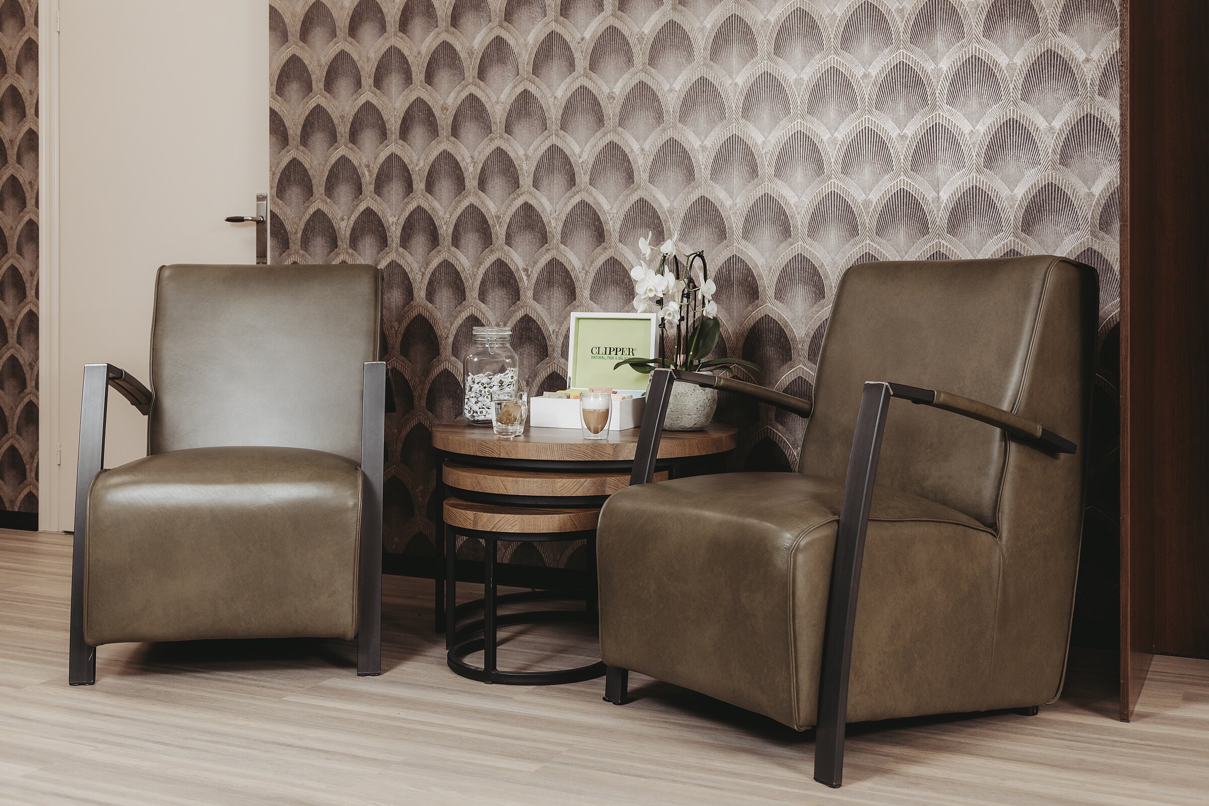 De wachtruimte met twee fauteuils en een lage tafel